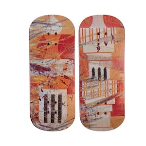 May include: Two fingerboards with a colorful abstract design featuring a tower-like structure. The fingerboards are made of wood and have a slightly curved shape.