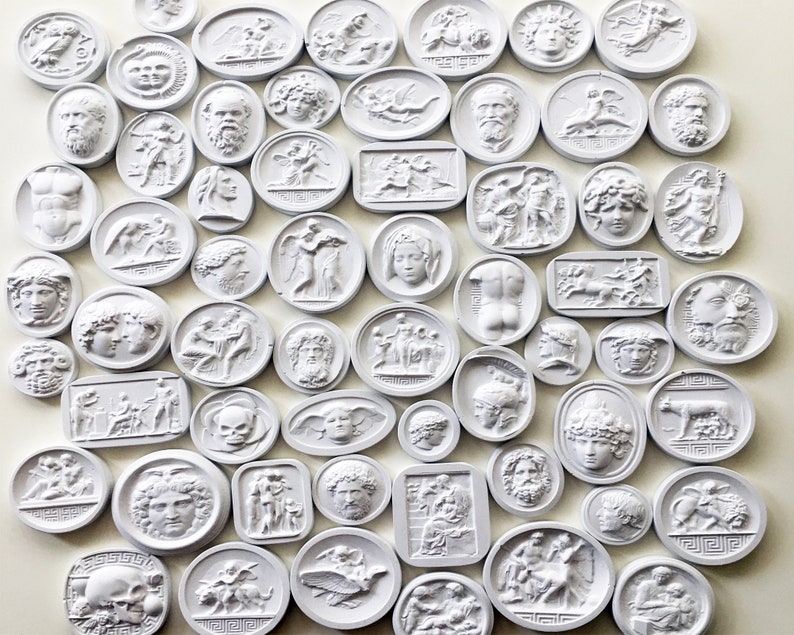 May include: A collection of white ceramic medallions with various designs, including mythological figures, animals, and abstract patterns. The medallions are arranged in a grid pattern on a white background.