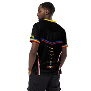 Puede incluir: Camiseta negra de manga corta con detalles amarillos, rojos y azules. La camiseta tiene un cuello amarillo y rayas rojas y azules en el pecho. El n&uacute;mero "68" est&aacute; en la manga izquierda. El texto "METEORA B BARBUDA" est&aacute; impreso en la parte trasera.