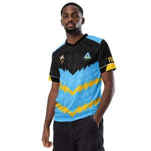 May include: A black and blue football shirt with a yellow lightning bolt pattern. The shirt has a small logo on the left chest and the text "SAINT LUCIA" on the right chest. The number "75" is on the right shoulder.
