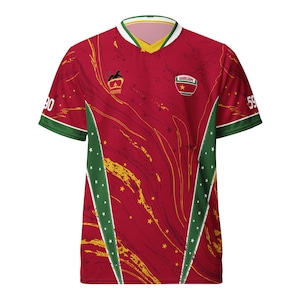 Peut inclure: Maillot rouge et or avec des touches de vert et de blanc. Le maillot présente un col en V avec une bordure jaune et blanche. Les manches ont une bordure verte avec des étoiles blanches. Le maillot porte le numéro 90 sur la manche gauche et 59 sur la droite.