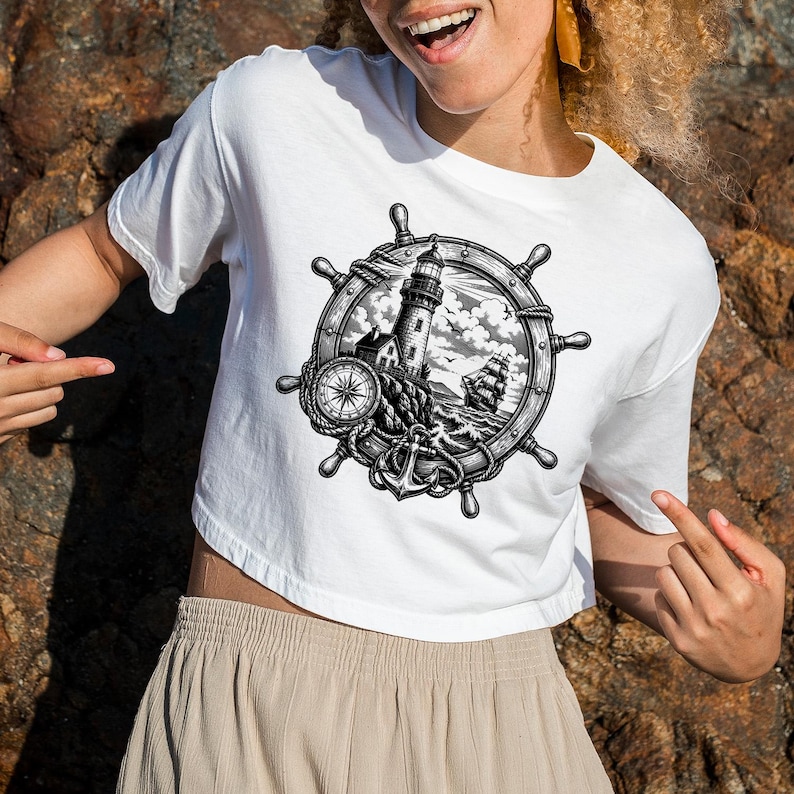May include: White crop top featuring a black and white nautical design. The design includes a ship's wheel, a lighthouse, a compass, an anchor, and a sailboat. The shirt is made of a soft, comfortable material.