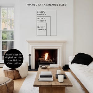 May include: A framed art print with a white background and black text listing different sizes available in inches and centimeters. The text reads "FRAMED ART AVAILABLE SIZES" and lists the following sizes: 24x32"/60x80cm, 18x24"/45x60cm, 12x16"/30x40cm. The print is displayed on a white wall above a fireplace with a roaring fire.