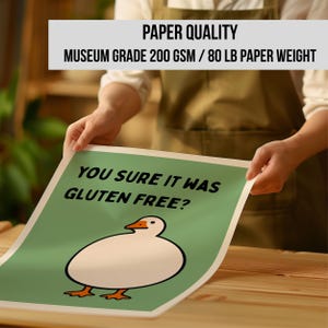 May include: A rectangular poster featuring a green background, a white cartoon goose, and the black text "YOU SURE IT WAS GLUTEN FREE?". The paper is museum grade 200 gsm or 80 lb paper weight. The design is centered on the white-bordered paper sheet.