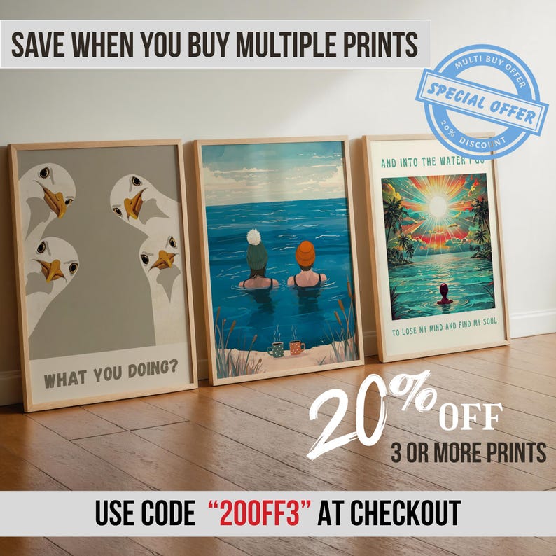 May include: Three framed art prints leaning against a wall. The prints feature illustrations of geese, people swimming in the ocean, and a tropical sunset. The prints are displayed on a wooden floor. The image includes text that says "What You Doing?" and "To Lose My Mind and Find My Soul."