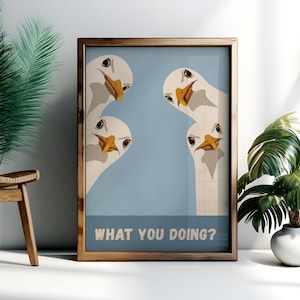 May include: Framed art print featuring four cartoon geese with white feathers, yellow beaks, and black eyes, set against a light blue background. The text "WHAT YOU DOING?" is displayed in a white font at the bottom of the print.