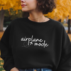 May include: Black sweatshirt with white text that reads "airplane mode" with a small airplane icon and a dashed line.