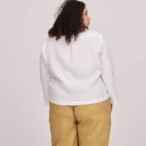 Pu&ograve; includere: Una camicia di lino bianca a maniche lunghe e dal taglio ampio. La camicia &egrave; indossata con un pantalone giallo senape.