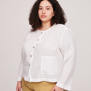 Pu&ograve; includere: Una camicia bianca in lino con bottoni, maniche lunghe e una tasca sul lato sinistro. La camicia ha una vestibilit&agrave; rilassata ed &egrave; realizzata in un tessuto leggero.
