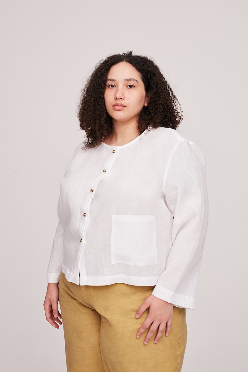 Pu&ograve; includere: Una camicia bianca in lino con bottoni, maniche lunghe e una tasca sul lato sinistro. La camicia ha una vestibilit&agrave; rilassata ed &egrave; realizzata in un tessuto leggero.