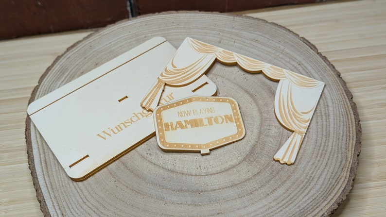 Peut inclure: Kit de bricolage en bois pour r&eacute;aliser une enseigne de cin&eacute;ma. Le kit comprend une enseigne indiquant "Now Playing Hamilton" et un rideau.