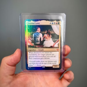 Peut inclure: Une carte Magic: The Gathering intitulée "Eternal Love" représentant un couple en tenue de mariage. La carte est dans une protection. Le texte décrit l'effet de la carte et inclut une citation d'Arwen.