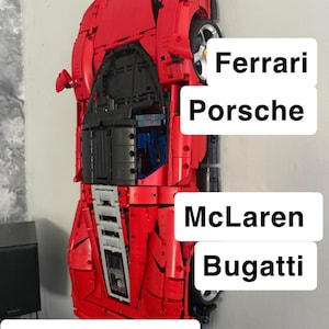 Könnte beinhalten: Rotes Modellauto an einer Wand montiert, mit dem Text "Wall mounts". Das Bild enthält auch die Namen "Ferrari", "Porsche", "McLaren", "Bugatti" und "Lamborghini".
