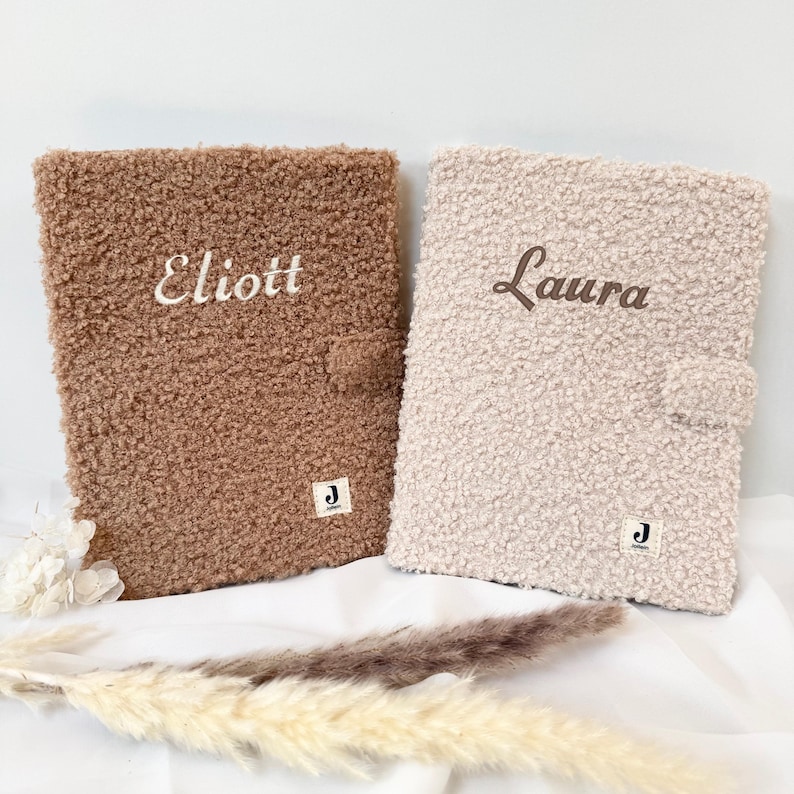 May include: Two personalized fluffy brown and white covers with the names "Elliott" and "Laura" embroidered on them.