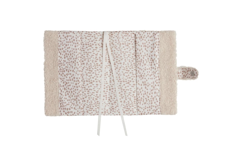 May include: A white book cover with a pink polka dot pattern and a soft, fluffy white border. The cover has two white ribbon ties.