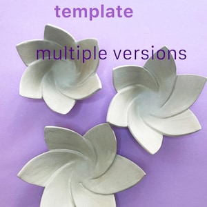Può includere: Tre oggetti a forma di fiore grigio chiaro con più petali sono disposti su uno sfondo viola. Il testo "modello stampabile" e "versioni multiple" si trova in alto a sinistra nell'immagine.