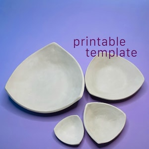 Könnte beinhalten: Vier cremeweiße, dreieckige Schalen in verschiedenen Größen, angeordnet auf einer violetten Fläche. Der Text "printable template" ist oben rechts in Violett aufgedruckt. Die Schalen haben glatte, matte Oberflächen und abgerundete Ecken.