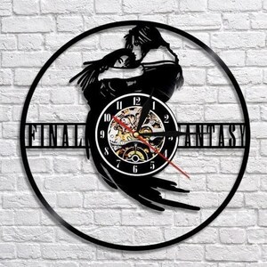May include: Black vinyl record clock featuring a silhouette of two figures embracing, with the words "FINAL FANTASY" cut out. The clock face is white with black numbers and a red second hand. The clock is mounted on a white brick wall.