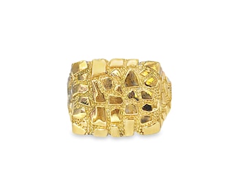 May include: A gold-colored ring with a textured surface. The ring has a rectangular shape with an irregular pattern of small, raised shapes, giving it a unique, eye-catching appearance. The ring is set against a white background.