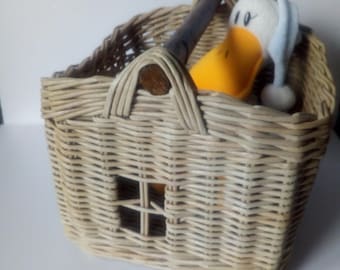 Rectangular wicker basket with a wooden handle for toys.
