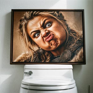 Puede incluir: Un lienzo rectangular enmarcado que presenta el retrato de una persona con cabello rubio, vestida con ropa oscura texturizada con detalles circulares metálicos, haciendo una mueca divertida con labios fruncidos y ojos muy abiertos, montado en una pared blanca sobre un inodoro.