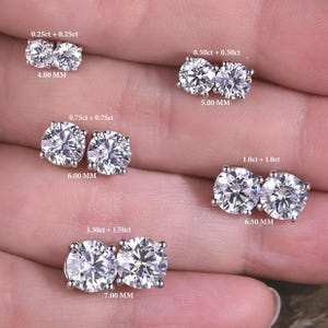May include: Five pairs of round-cut stud earrings in silver-toned settings, labelled with sizes: 0.25ct+0.25ct (4.00 mm), 0.50ct+0.50ct (5.00 mm), 0.75ct+0.75ct (6.00 mm), 1.0ct+1.0ct (6.50 mm), and 1.50ct+1.50ct (7.00 mm).