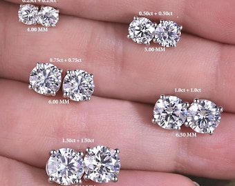May include: Five pairs of round-cut stud earrings in silver-toned settings, labeled with sizes: 0.25ct+0.25ct (4.00 mm), 0.50ct+0.50ct (5.00 mm), 0.75ct+0.75ct (6.00 mm), 1.0ct+1.0ct (6.50 mm), and 1.50ct+1.50ct (7.00 mm).