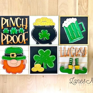 May include: Six wooden signs with a St. Patrick's Day theme. The signs feature a pot of gold, a beer mug, a leprechaun, a shamrock, the words "Pinch Proof", and the words "Lucky" with elf shoes.