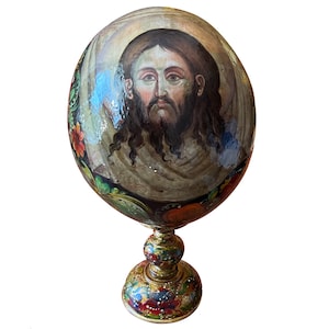 A painted ostrich egg on a stand.