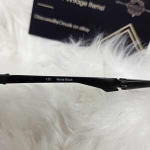 Puede incluir: Primer plano de unas gafas negras con el texto "120 Matte Black" impreso en la montura.