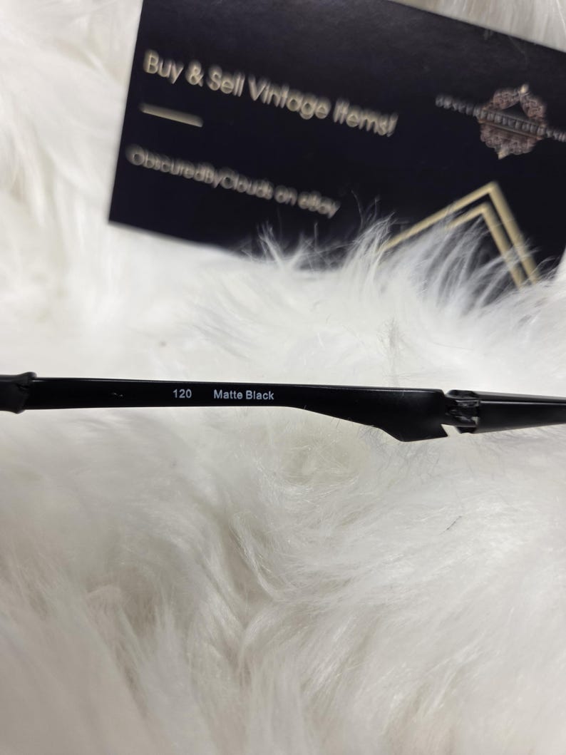 Puede incluir: Primer plano de unas gafas negras con el texto "120 Matte Black" impreso en la montura.