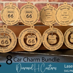 May include: A bundle of eight Route 66 car charms made of light-colored wood. Each charm features the Route 66 shield logo, the years 1926-2026, and the distance of 2,448 miles. The charms are laser cut and have a hole for hanging.