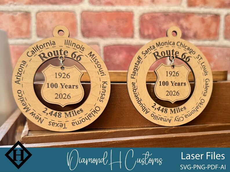 May include: Two wooden Route 66 ornaments. Each ornament features the text "Route 66", the years "1926" and "2026", and the words "100 Years". The ornaments also list the cities and states along the route. The text "2,448 Miles" is also included.