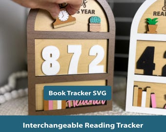 May include: A wooden arch-shaped reading tracker with a dark brown frame and light wood background. It features large white numbers 872, a small clock icon, a green cactus, and colourful book cutouts. The text reads READ THIS YEAR.