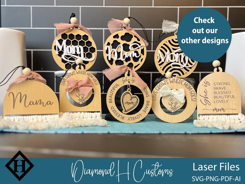 May include: Wooden laser-cut ornaments with the words "Mom" and "Mama" in various designs. Some ornaments have decorative bows and macrame fringe. The image also includes the text "Check out our other designs."