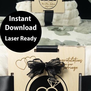 May include: A wooden ornament featuring a ring design with the inscription "Congratulations on your marriage" and "Mr. & Mrs. Anderson July 07, 2025". The ornament measures 3 inches by 3.48 inches. A white faux fur blanket is in the background.