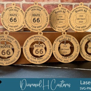 May include: Wooden Route 66 ornaments with a circular design. Each ornament features the Route 66 shield, the years 1926-2026, and the text "2,448 Miles." The ornaments are laser cut and include various state names.