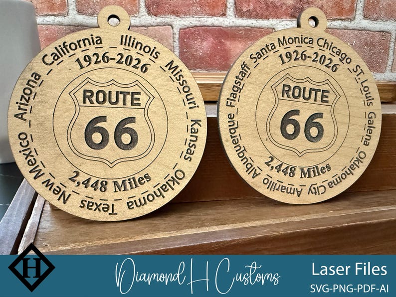 May include: Two wooden Route 66 ornaments. Each ornament features the Route 66 shield logo with the number 66. The text "2,448 Miles" is below the logo. The ornaments are engraved with the names of cities and states along Route 66.
