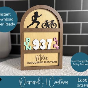 May include: Wooden activity tracker with a running figure and a bicycle silhouette. The tracker displays "937 Miles CONQUERED THIS YEAR." The design includes the words "RUN" and "BIKE" with interchangeable letters. The text "Instant Download Laser Ready" is also visible.
