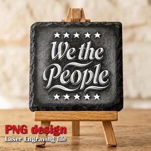 Könnte beinhalten: Ein quadratischer, dunkelgrauer Schieferuntersetzer mit dem Schriftzug "We the People" in weißer Schrift, umrahmt von weißen Sternen. Der Untersetzer wird auf einer kleinen Holzstaffelei präsentiert. Der Text "PNG design Laser Engraving file" ist unten in Rot und Weiß.