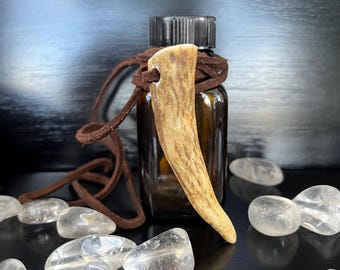 Collar con aceite ritual y talismán de asta de ciervo guardián del bosque: intuición, protección y fuerza.