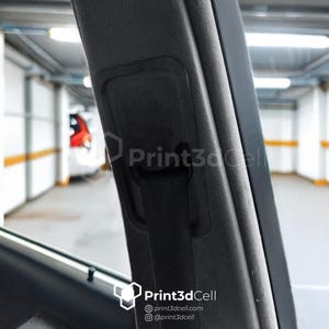 Op de afbeelding: Close-up van een zwarte autogordelgesp en -band, met een zwarte kunststof behuizing. De gesp bevindt zich in ingetrokken positie. De autogordel bevindt zich in een auto-interieur.