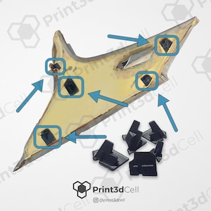 Peut inclure: Un objet angulaire de couleur or avec plusieurs clips noirs attachés, ainsi qu'un groupe de clips noirs détachés. L'image comprend des flèches pointant vers les clips et l'objet. Le logo Print3dCell est dans le coin inférieur droit.