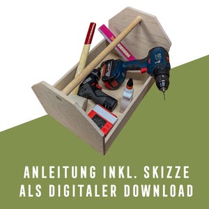 Puede incluir: Un organizador de herramientas de madera con varias herramientas, incluyendo un martillo, un taladro y pegamento. El organizador es de madera clara y tiene un asa. La imagen también incluye el texto: ANLEITUNG INKL. SKIZZE ALS DIGITALER DOWNLOAD.