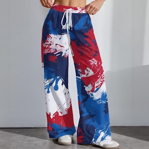 以下が含まれることがあります： 赤、白、青の鮮やかな抽象デザインが施されたワイドレッグパンツ。 パンツは、ドローストリングウエストと流れるようなシルエットが特徴です。 大胆なカラーパレットと芸術的なパターンが、印象的な視覚的ステートメントを生み出しています。