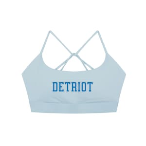 May include: A light blue sports bra with thin, crisscrossing straps in the back. The word "DETRIOT" is printed across the front in blue block letters.