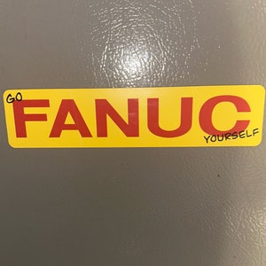 May include: A yellow sticker with the word "FANUC" in red letters. The sticker has the words "GO YOURSELF" written in black on the bottom right corner.