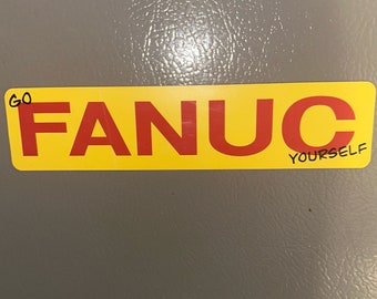 May include: A yellow sticker with the word "FANUC" in red letters. The sticker has the words "GO YOURSELF" written in black on the bottom right corner.