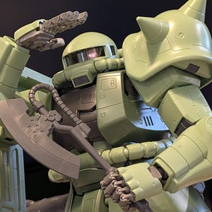 Op de afbeelding: Een lichtgroene robotactiefiguur met een gedetailleerd ontwerp. De figuur houdt een grijze bijl vast en heeft een hand omhoog. De robot heeft een helm, schouderpantser en meerdere gewrichten. Een verzamelobject.