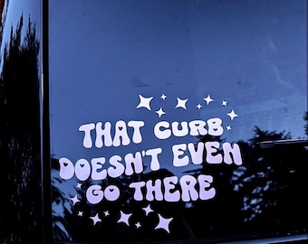 May include: A white vinyl decal with the text "THAT CURB DOESN'T EVEN GO THERE" in a retro font, with star accents. The decal is applied to a dark surface, likely a car window.